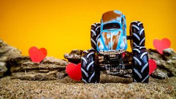 Minahasa, Indonesia December 2022, toy car with gradient orange background and a heart photo