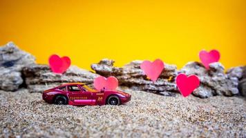 Minahasa, Indonesia  December 2022, toy car with gradient orange background and a heart photo