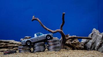 minahasa, Indonesia  January 2023, toy car on a pile of coins, saving for the future, managing successful transportation business technology concept photo