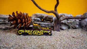 toy car hauling pinecones on an orange background photo