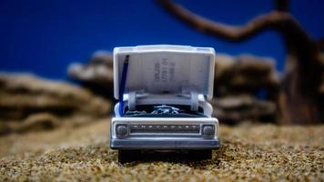 minahasa, Indonesia  January 2023, a toy car on the sand with a background of rocks and blue sky photo