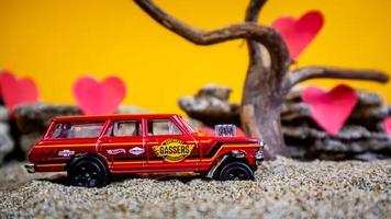 Minahasa, Indonesia December 2022, toy car with gradient orange background and a heart photo
