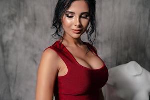 girl in a red evening dress on a gray background photo