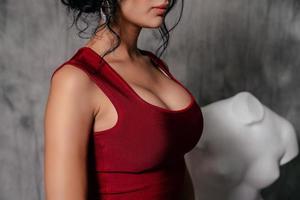 girl in a red evening dress on a gray background photo