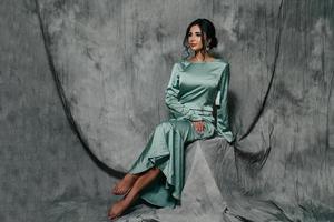 portrait of a girl in a wedding dress on a gray background photo