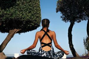 Girl meditates in nature back view