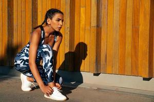 sports girl on a wooden wall background photo