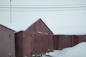 Garages in winter. Garages in snow. Roofs of houses in snow. photo