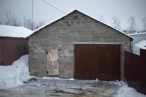 Garage for transport. Concrete house. Rusty gates. Garage block. photo