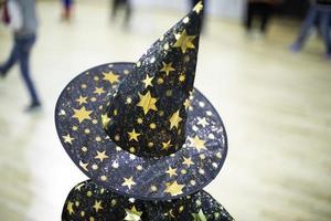 Wizard hat. Child at holiday. Cap on head. Details of children's play. photo