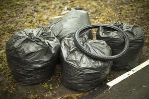 Bags of garbage on street. Black bags. Cleaning in yard. photo