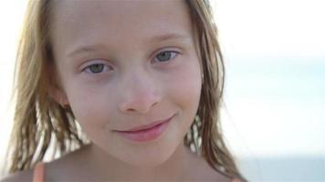 feliz pequeno menina desfrutando feriado período de férias em a de praia video