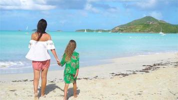 Beautiful mother and daughter on Caribbean beach. Family on beach vacation.