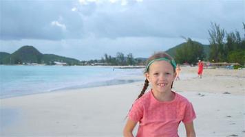 jolie petite fille au chapeau à la plage pendant les vacances dans les Caraïbes