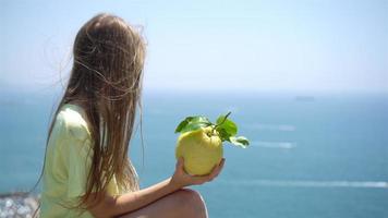 gros citron jaune à la main sur fond de mer et de ciel méditerranéens. video