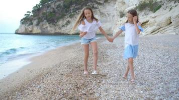 aktiva liten flickor på strand har en massa av roligt. video