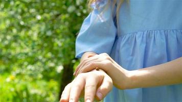 poco ragazza nel fioritura Mela albero giardino su primavera giorno giochi con coccinella video