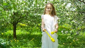 adorable niñita en un floreciente jardín de manzanas en un hermoso día de primavera video