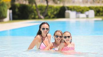 mère et deux enfants profitant des vacances d'été dans une piscine de luxe