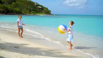 Kleine entzückende Mädchen, die am Strand mit Ball spielen video