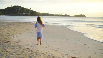 Adorable happy little girl on white beach at sunset video