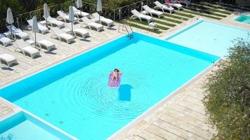 Young woman in bikini air mattress in the big swimming pool video