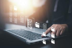 Businessman working on laptop with virtual screen. Online documentation database, IT consultant being set up Virtual Document Management System with laptop,Software for archiving corporate files. photo