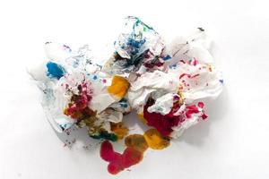 Toilet paper that is stained with colourful ink isolated on white paper background. photo