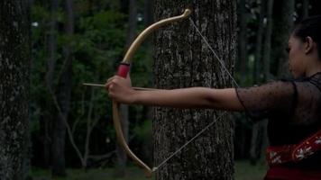 femmes asiatiques prêtes à tirer une flèche de l'arc tout en se tenant courageusement