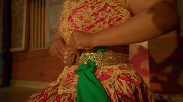 mujer indonesia con un pañuelo verde en el vientre y un vestido naranja en el cuerpo video