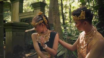 un homme flirtant avec sa petite amie assis dans la forêt portant une couronne dorée et un costume doré video