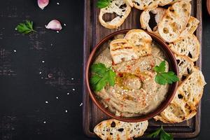 Baba ghanoush vegan hummus from eggplant with seasoning, parsley and toasts. Baba ganoush. Middle Eastern cuisine. Top view, overhead photo