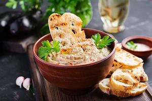 Baba ghanoush vegan hummus from eggplant with seasoning, parsley and toasts. Baba ganoush. Middle Eastern cuisine. photo