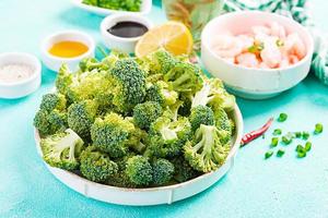 Ingredients for cooking stir fry shrimp with broccoli close up on a table. Prawns and broccoli. photo