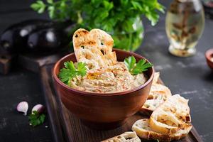 Baba ghanoush vegan hummus from eggplant with seasoning, parsley and toasts. Baba ganoush. Middle Eastern cuisine. photo