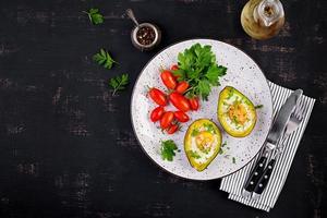 Avocado baked with egg and fresh salad. Vegetarian dish. Top view, overhead.  Ketogenic diet. Keto food photo