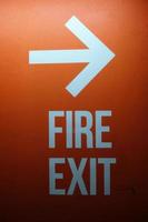 Fire Exit Sign on Red Concrete Wall Background. photo