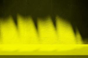 amarillo estuco mesa con naturaleza sombra en hormigón pared textura fondo, adecuado para cosmético producto presentación fondo, mostrar, y burlarse de arriba. foto