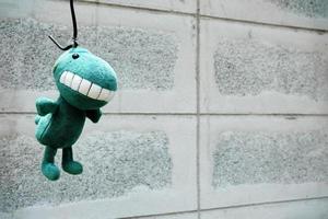 Left Dinosaur Doll Hanging on the Wall. photo