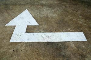 White Turn Right Arrow Sign on the Concrete Road. photo