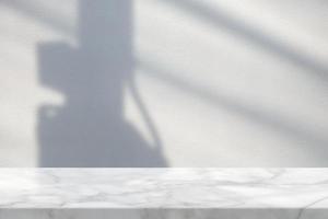 White Marble Table with High Voltage Pole Shadow on Concrete Wall Surface. photo