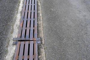 agua desagüe con metal cubrir en el asfalto la carretera. foto