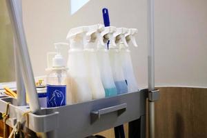 Close up Cleansing Spray Bottles on Cart. photo