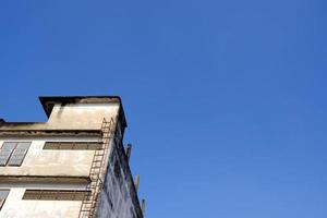 Fire Escape Ladder of Old Building with Blue Sky Background. photo