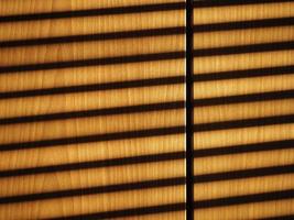 blinds shadow on wooden wall background photo