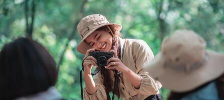 joven mujer bonita usa cámara tomando fotos a sus amigos