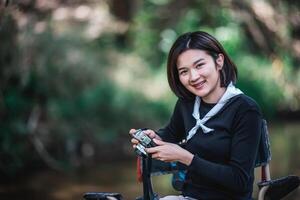 una mujer bonita joven usa una cámara para tomar fotos en un parque natural