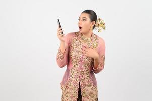 Young beautiful woman dress up in local culture in southern region pose with smartphone photo