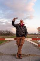 middle aged man wearing winter clothes taking a selfie in a country road - concept of people in recreation photo