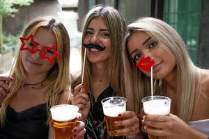 bonito hembra milenario novias tener divertido bebiendo cerveza al aire libre en vacaciones foto